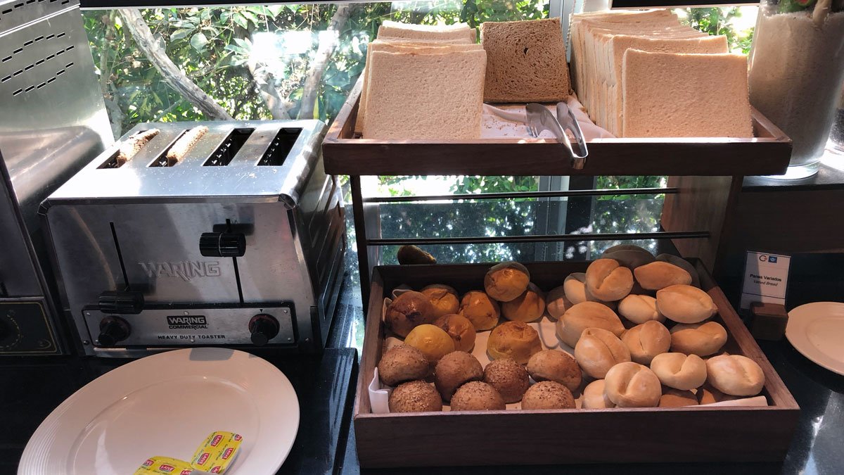 bread and rolls on a shelf next to a toaster