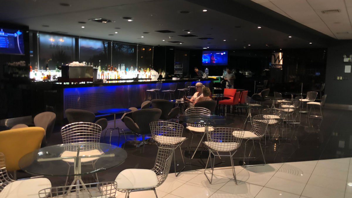 a group of people sitting at tables in a room with a bar