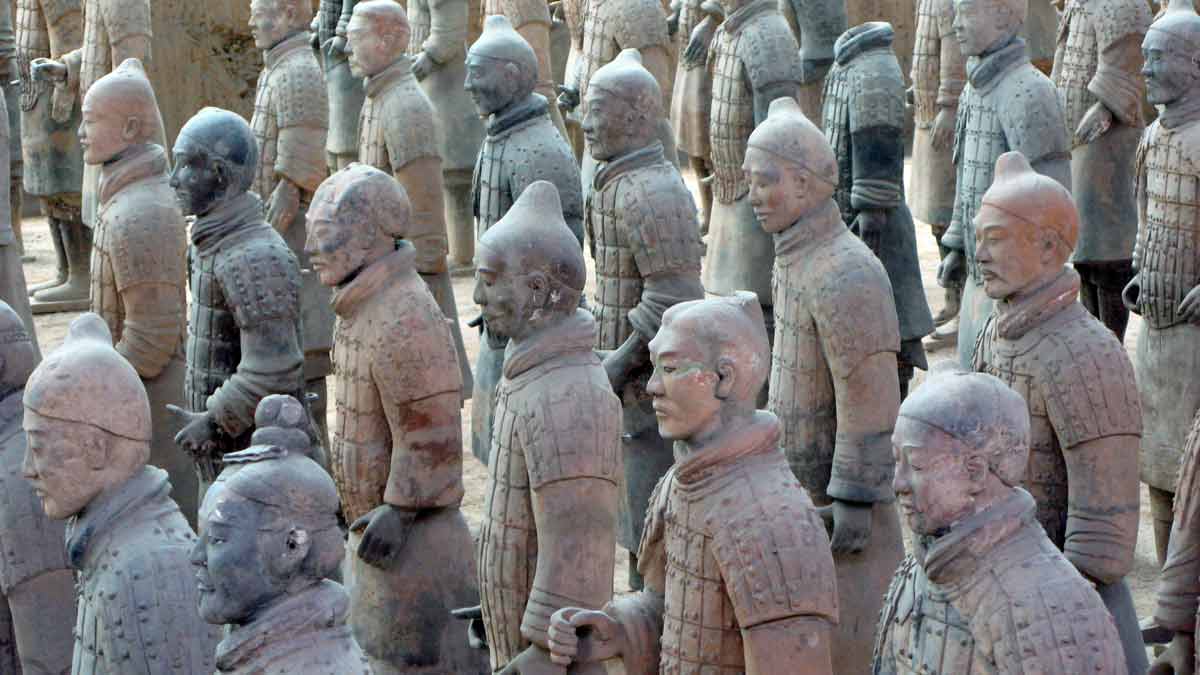 a group of statues of people with Terracotta Army in the background