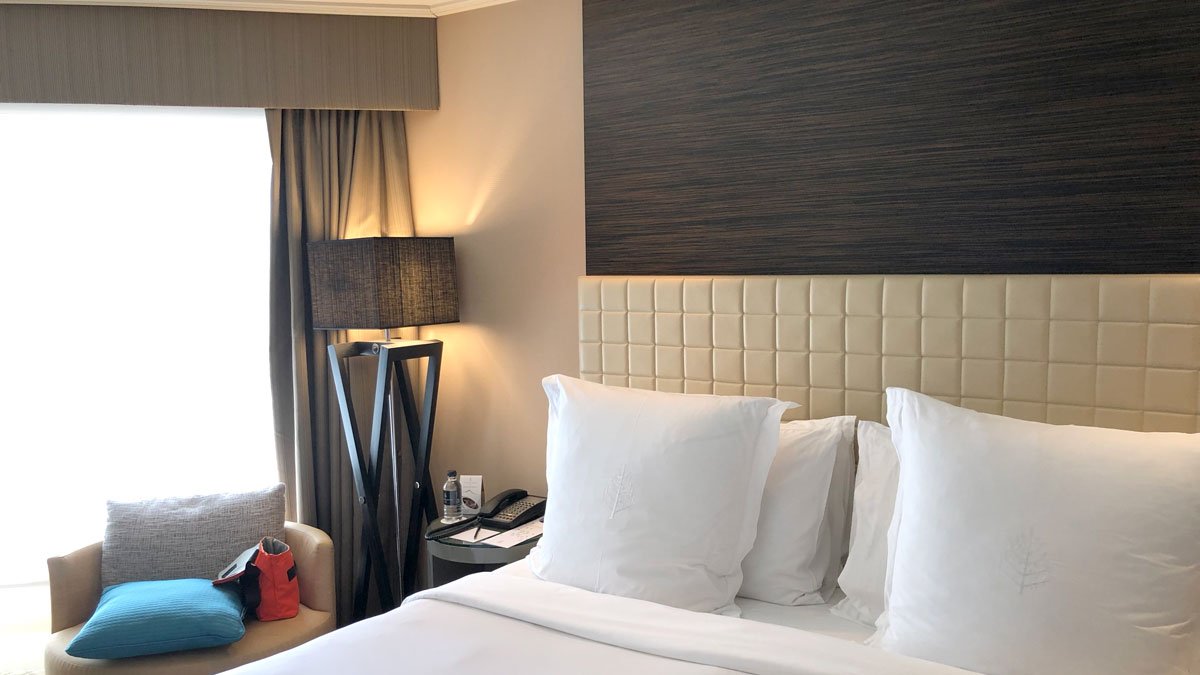 a bed with white pillows and a lamp in a hotel room