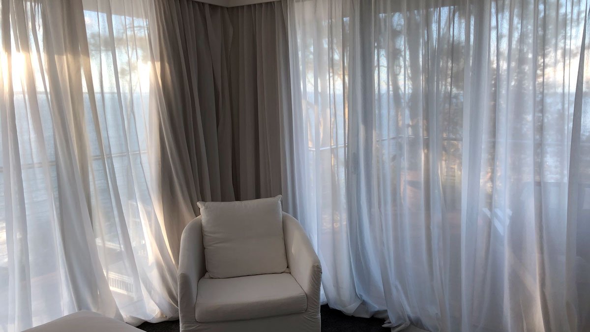 a white chair in a room with curtains