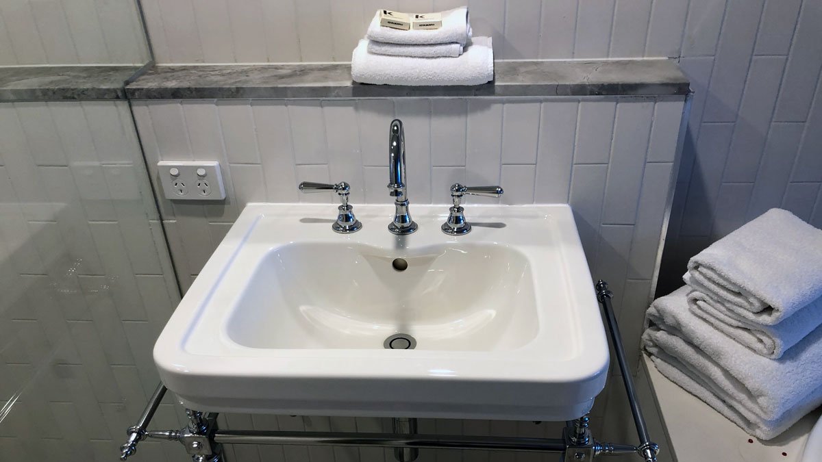 a sink with silver faucets and towels