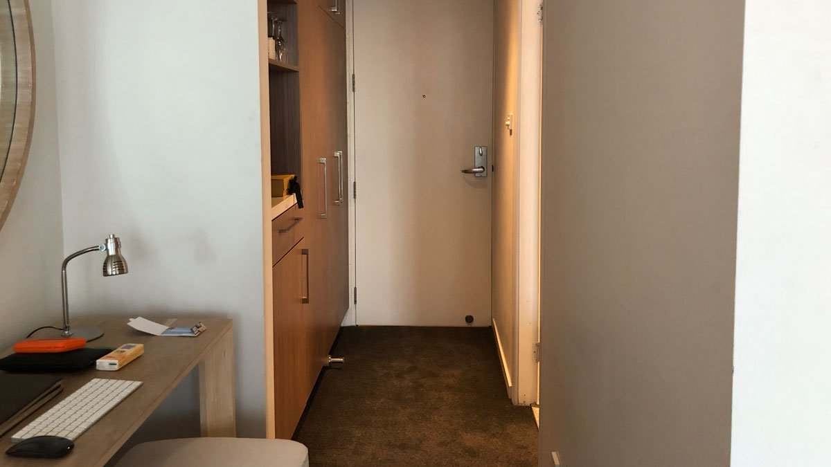 a hallway with a door and a shelf