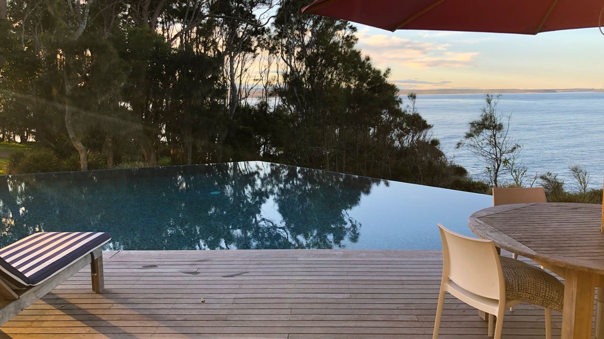 a pool with a chair and a table in front of it