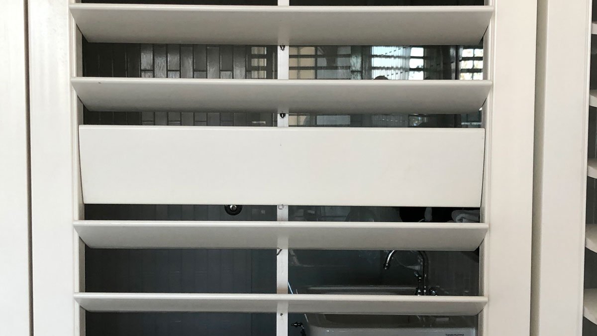 a white shelf with a sink and a window