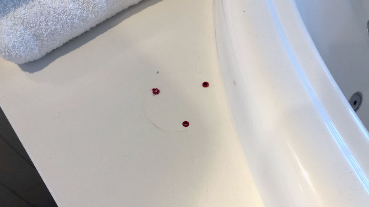 a white surface with red screws