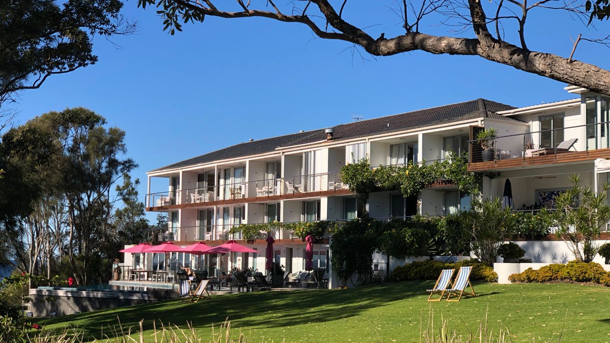 a building with lawn chairs and umbrellas