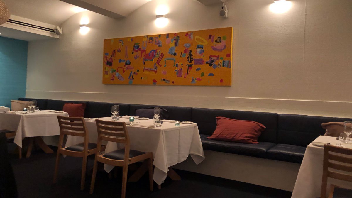 a table with a white tablecloth and chairs in a restaurant