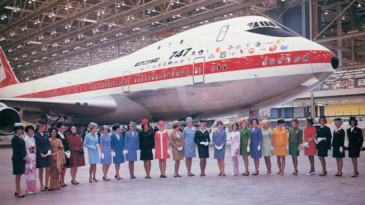 a group of people standing in front of a plane