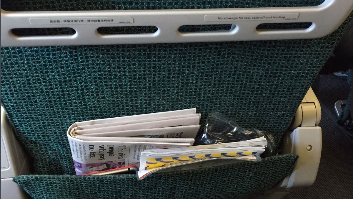 a group of newspapers in a pocket of a seat