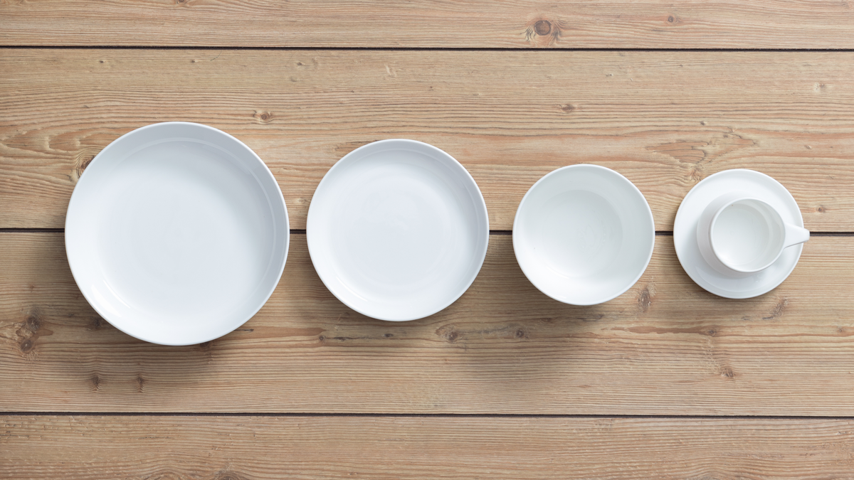 a row of white plates on a wood surface
