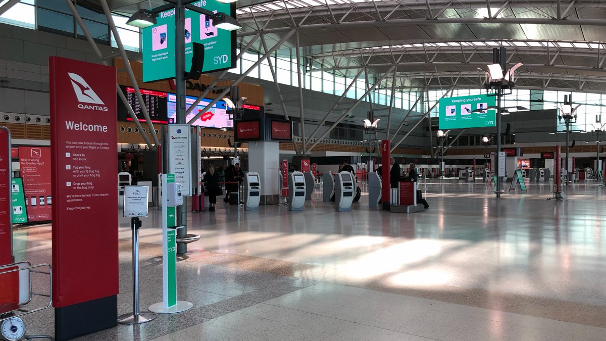 a large airport terminal with signs and people