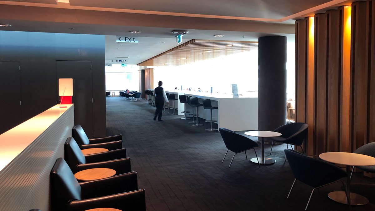 a man walking in a room with chairs and tables