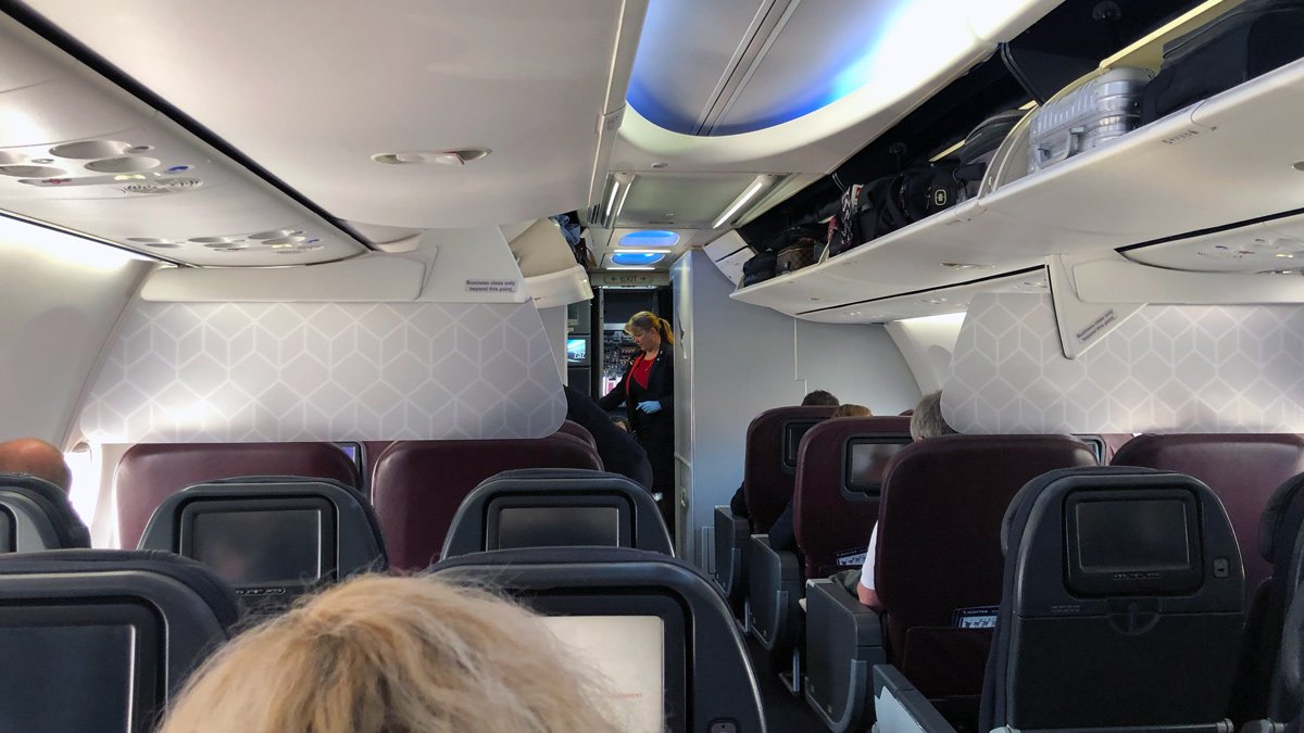 a woman standing in the door of an airplane