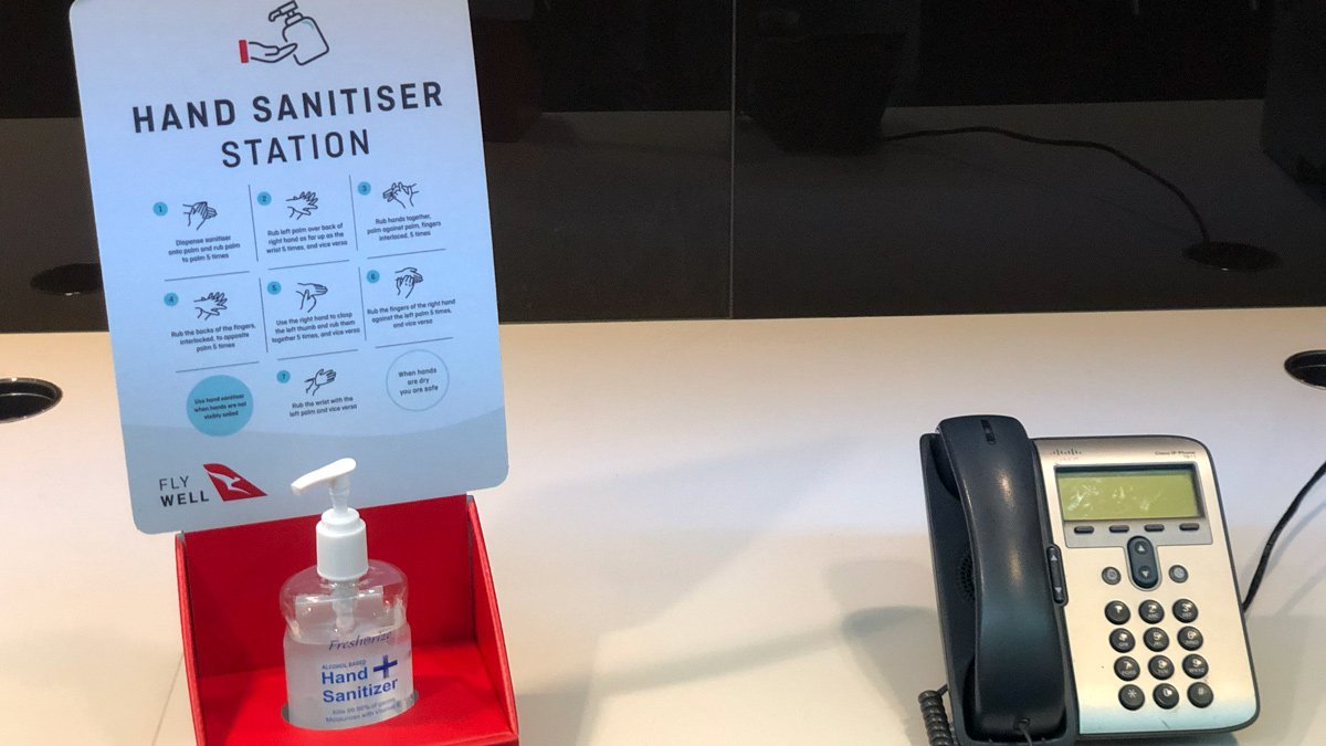 a hand sanitizer and a phone on a desk