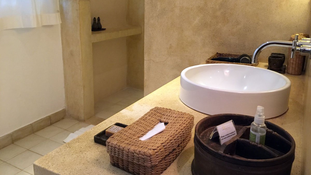 a bathroom with a sink and a basket of tissue