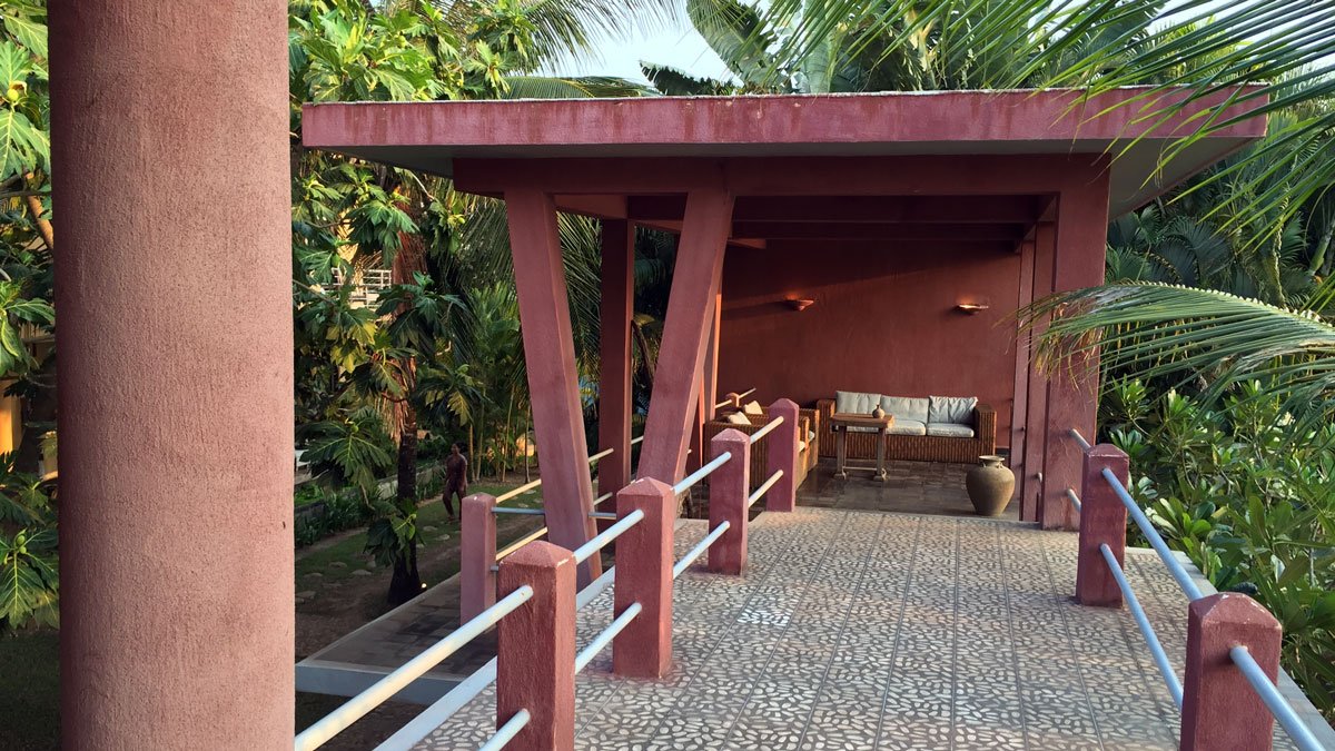 a red building with a bench and a railing