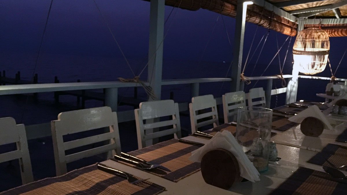 a table set for dinner with chairs and a napkin on it