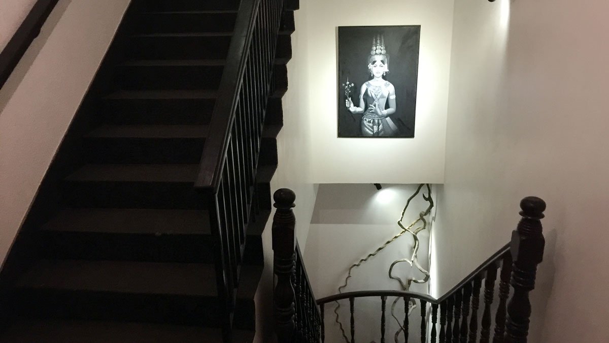 a staircase with a painting on the wall