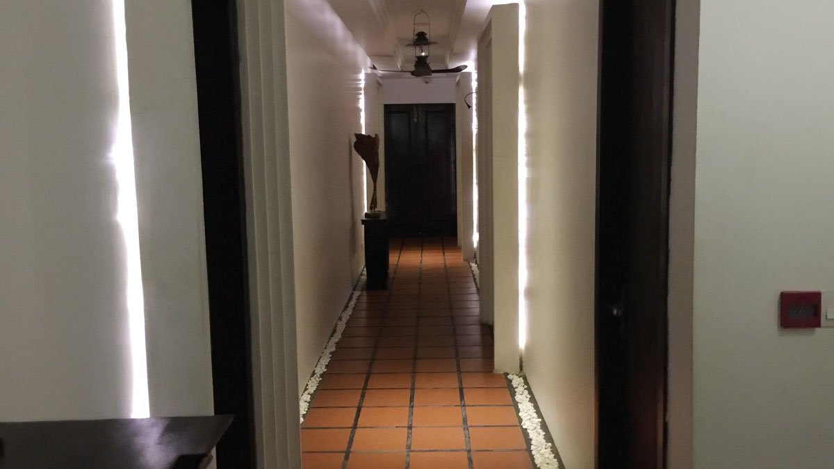 a hallway with a tile floor and a ceiling fan