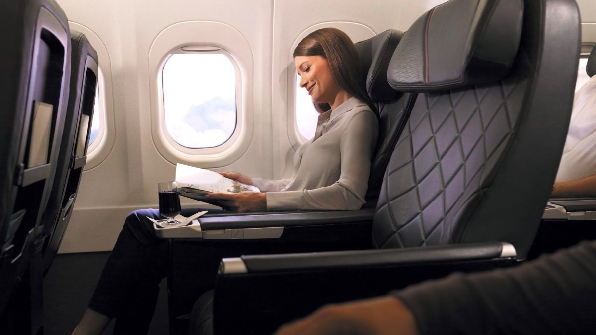 a woman reading a book on an airplane