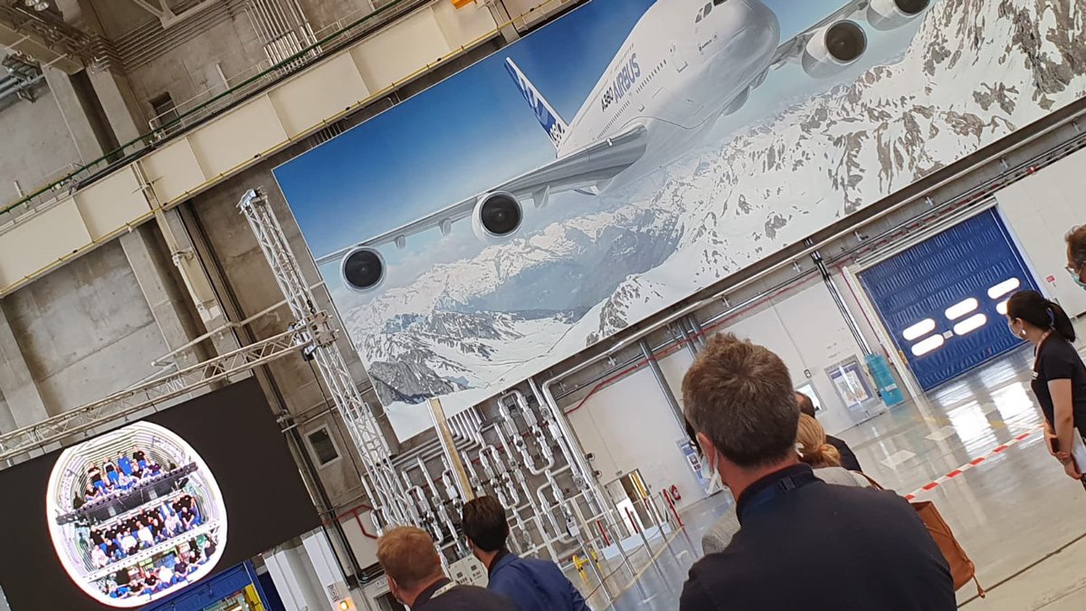 a group of people looking at a large poster