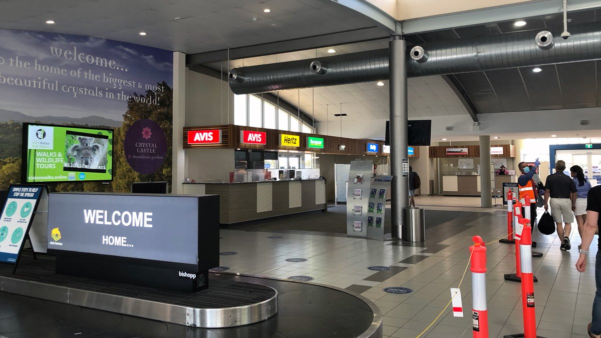 a large airport terminal with signs and a large sign