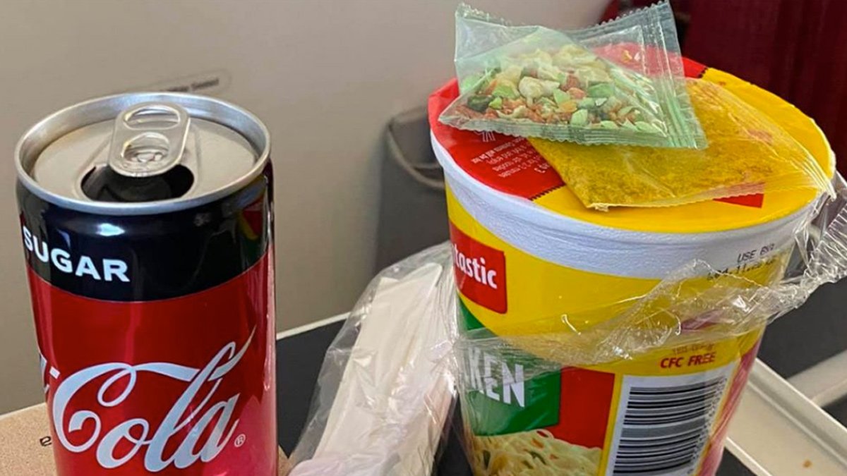 a can of soda and food on a table