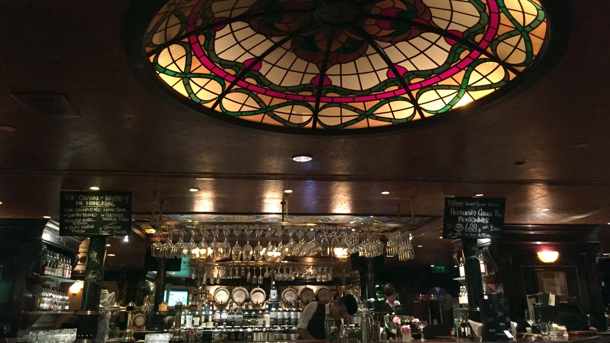 a stained glass ceiling with a stained glass window above a bar