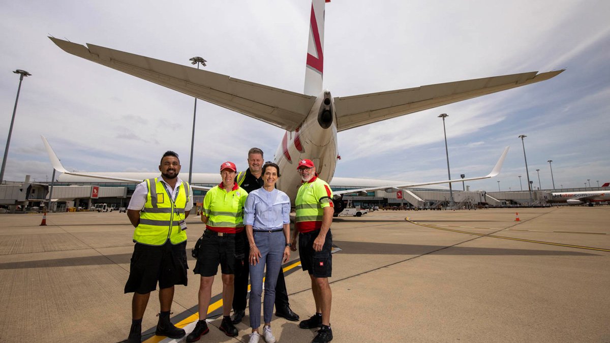 a group of people standing in front of an airplane