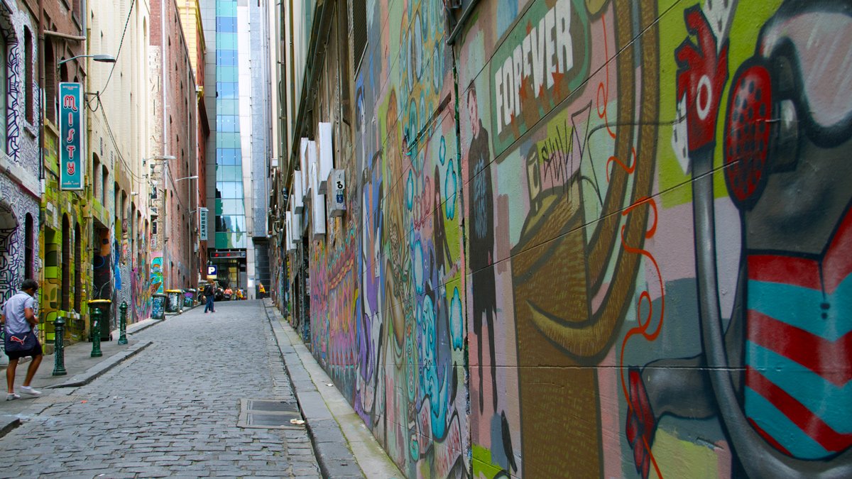 a street with graffiti on the side of a building