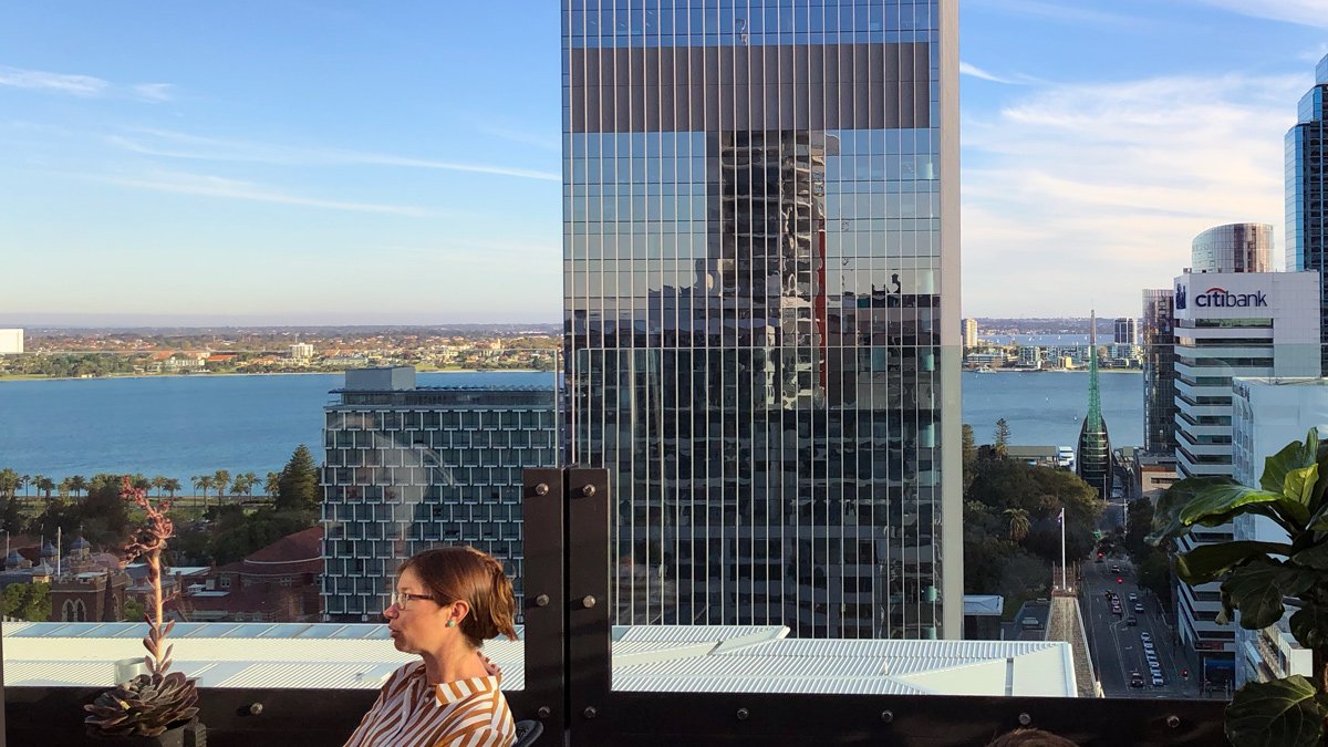 a woman sitting on a balcony overlooking a city