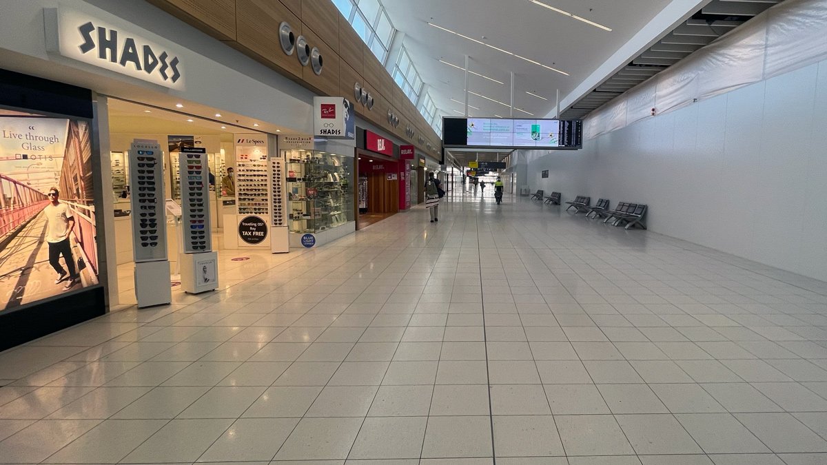 a large white tiled hallway with people walking in it