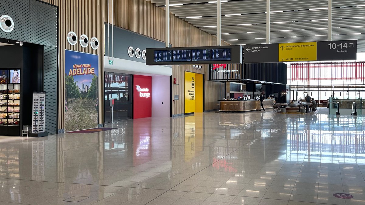a large airport terminal with signs and a counter