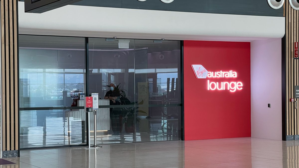 a glass door with a person standing in front of a red wall