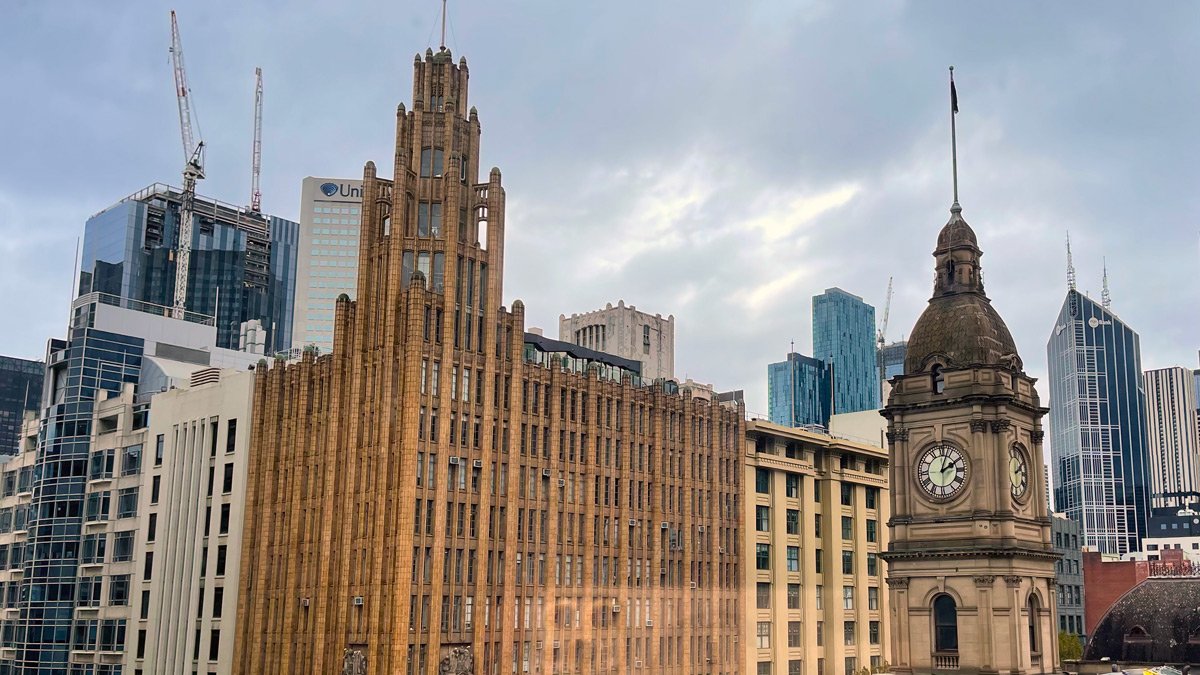 a large building with a clock tower and a tower in the background