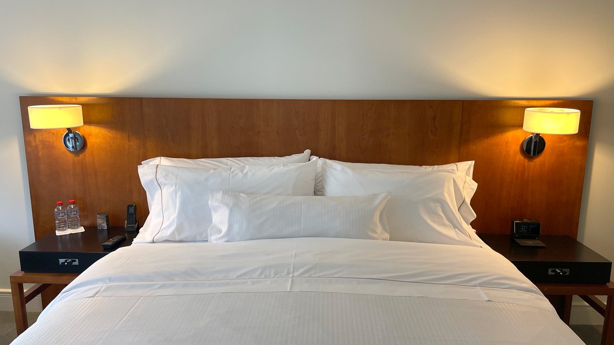 a bed with white sheets and pillows