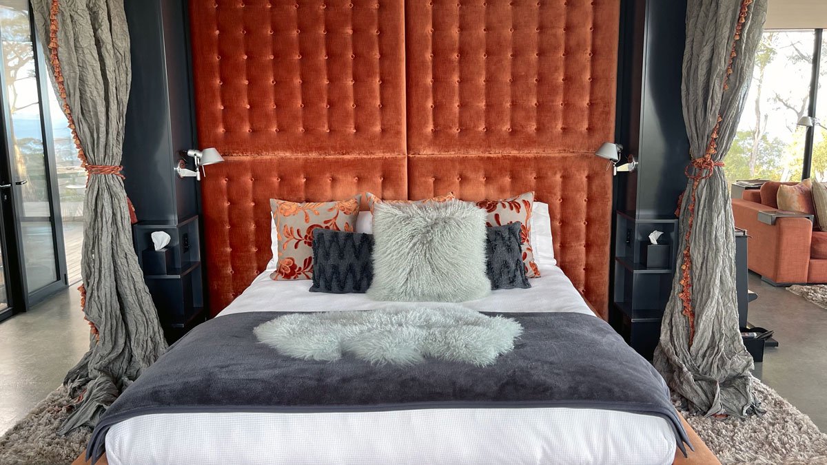a bed with pillows and a large headboard