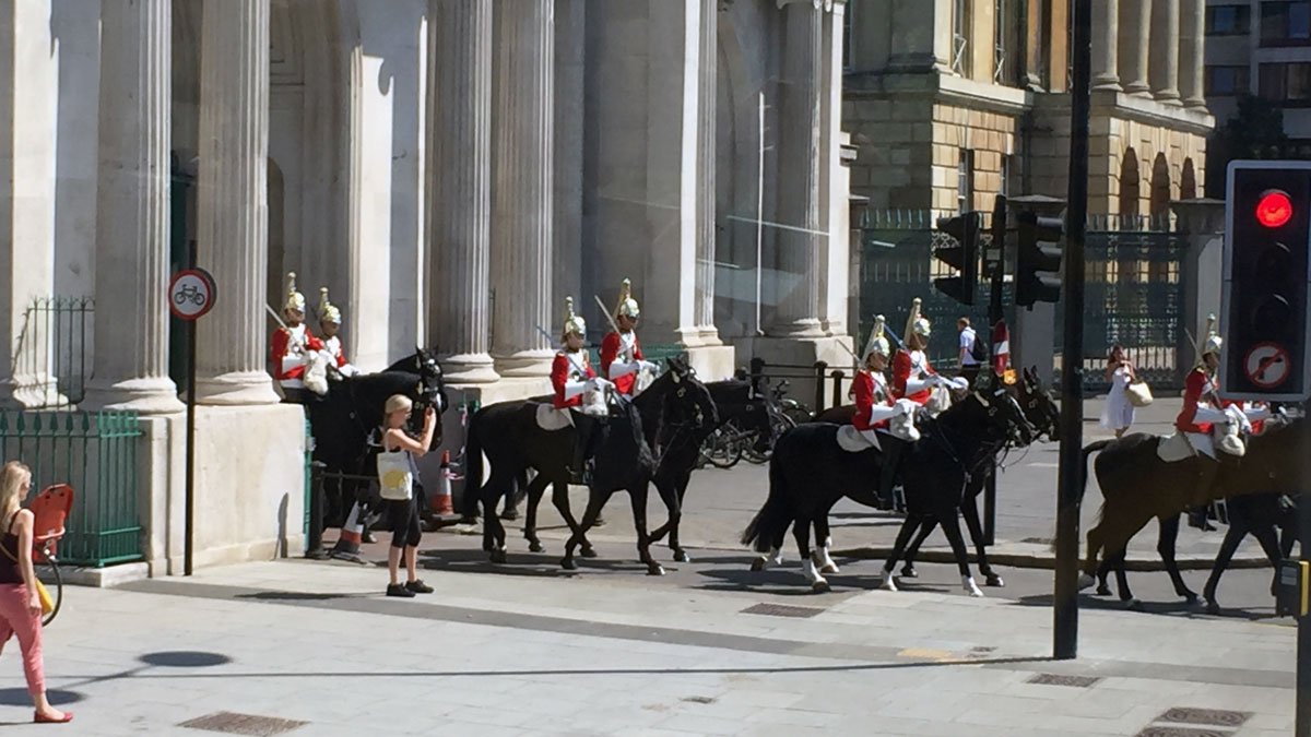 a group of people riding horses in front of a building