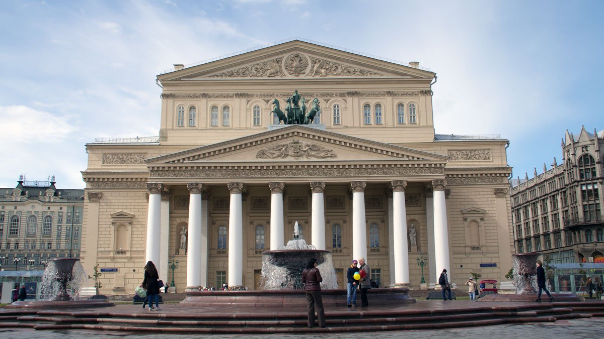 a large building with columns and a fountain with Bolshoi Theatre in the background