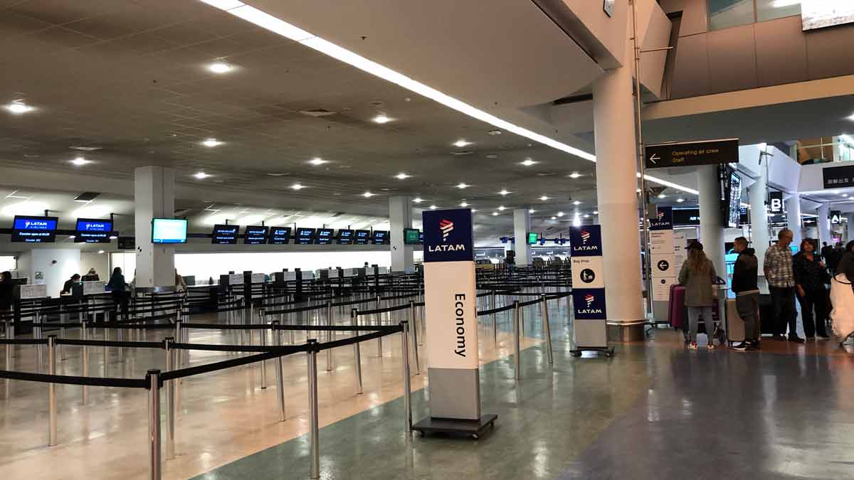 an airport terminal with a few signs and a row of screens