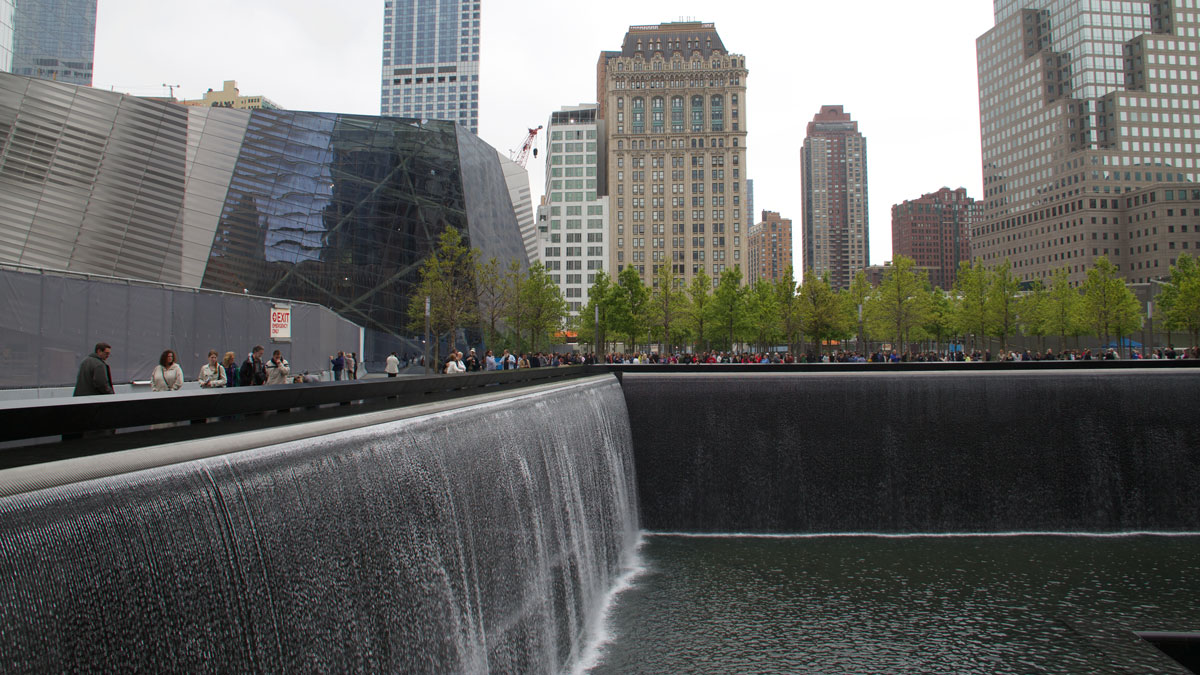 a water fall with people walking around