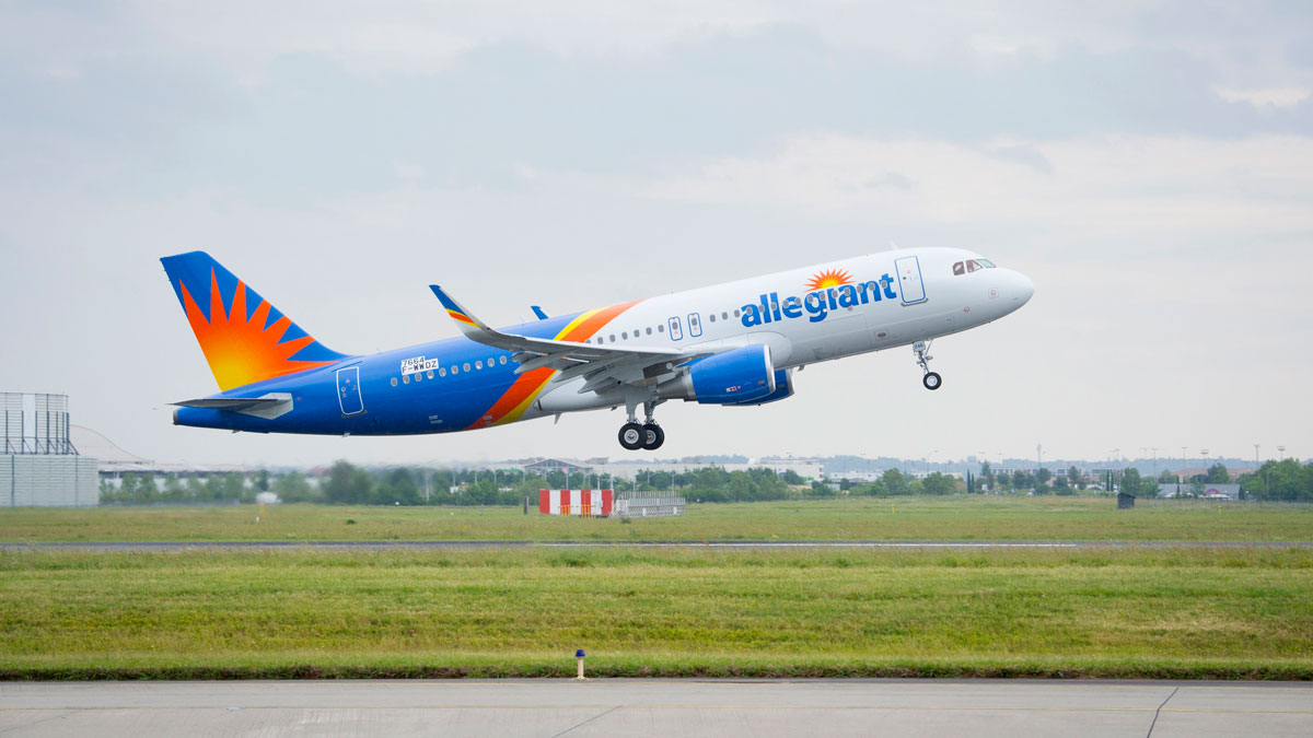 a blue and orange airplane taking off