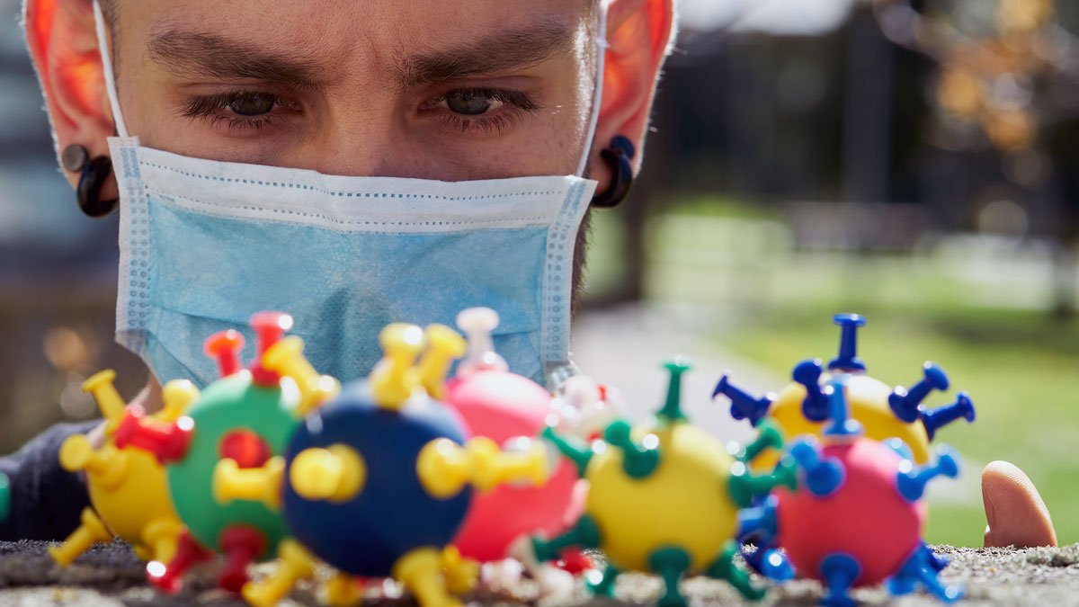 a person wearing a mask looking at colorful balls