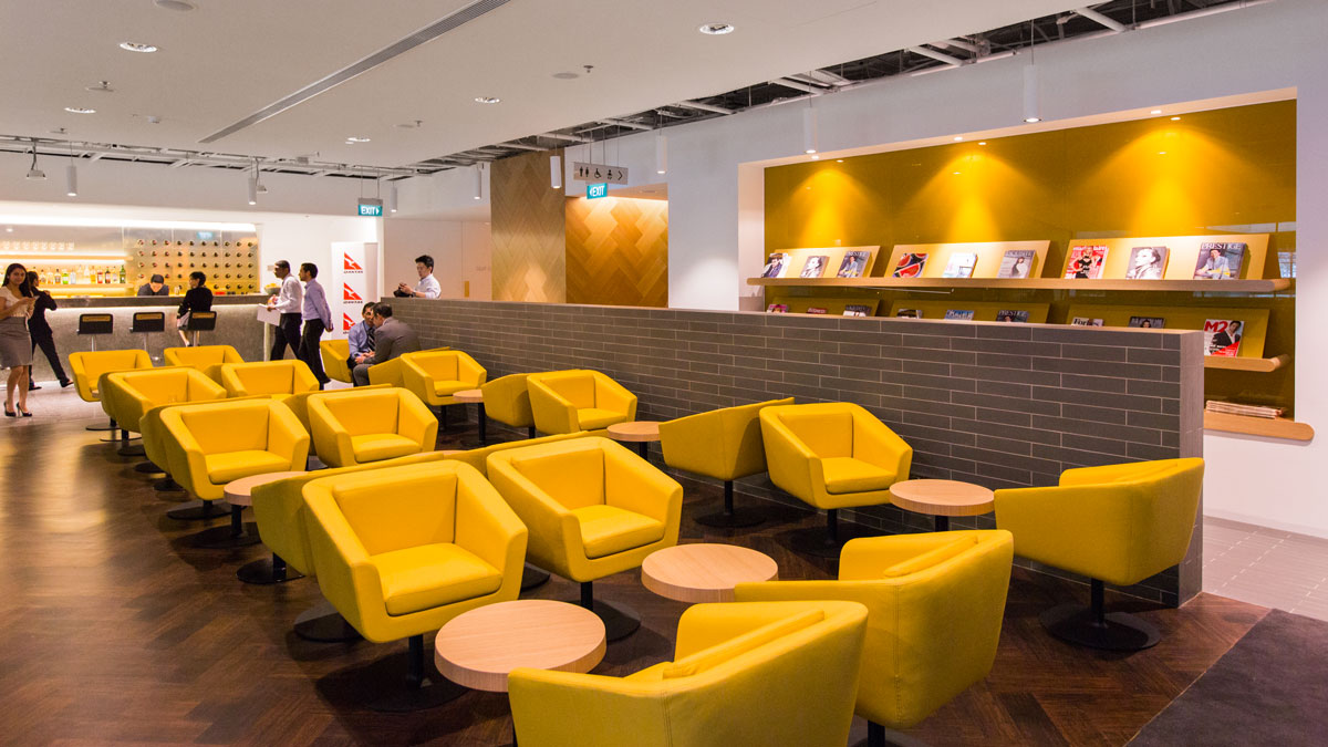 a group of people in a room with yellow chairs and tables