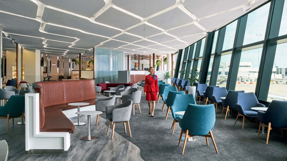 a woman walking in a room with chairs and tables