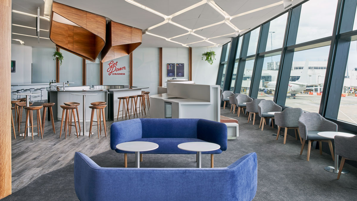 a room with blue couches and tables and chairs