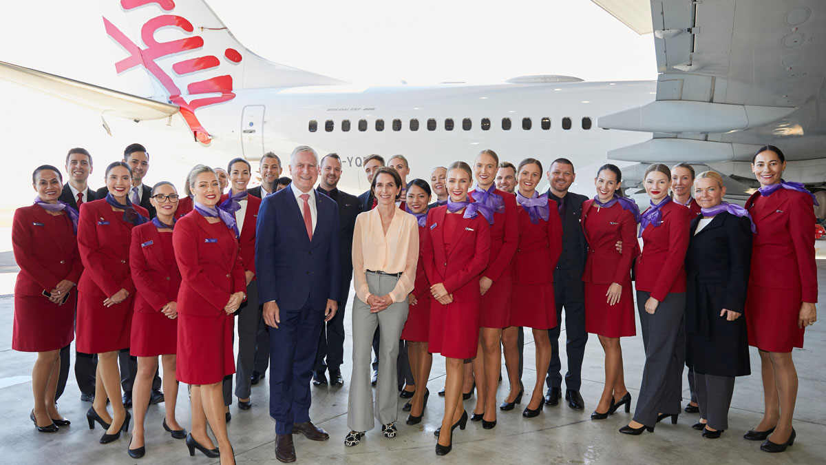 a group of people standing in front of a plane