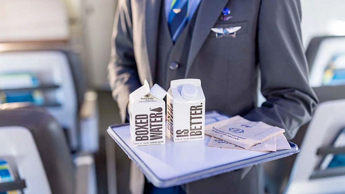 a person holding a tray with milk cartons and packages