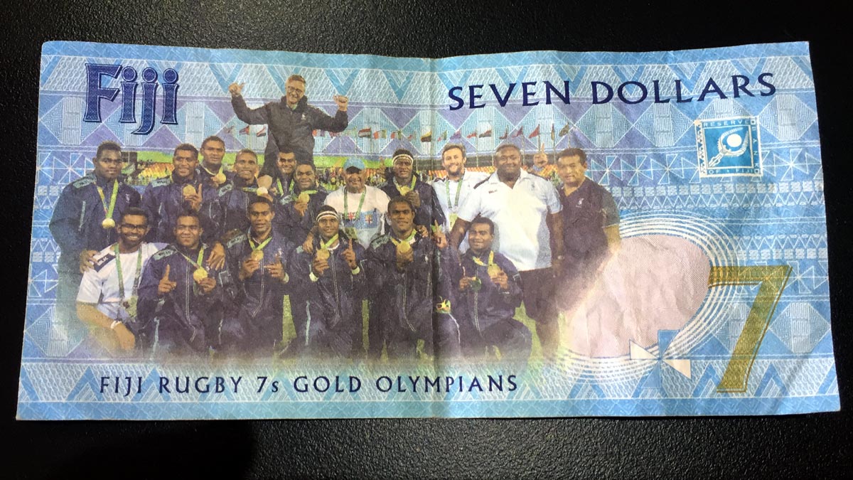 a paper money with a group of people posing for the camera
